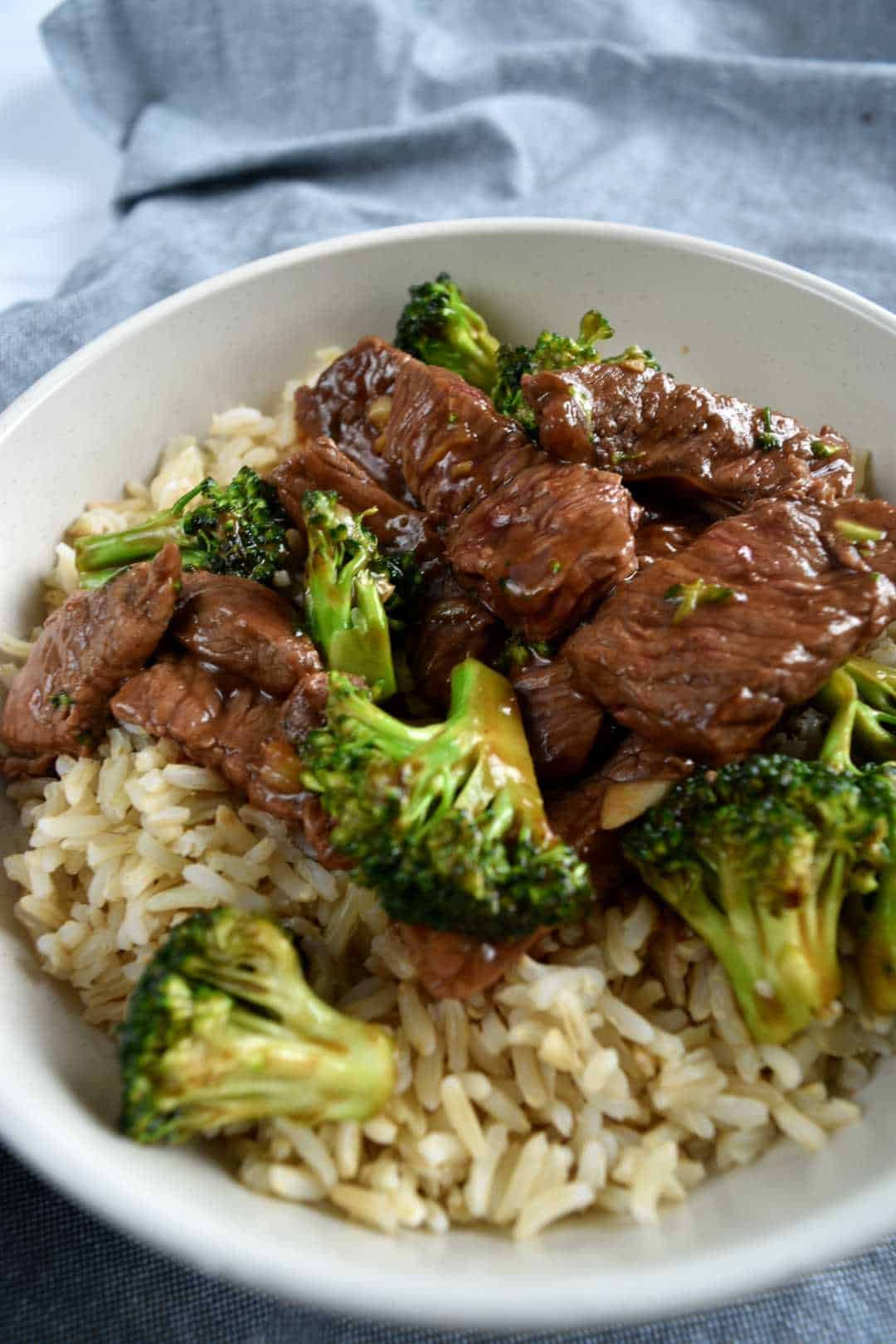 Beef and broccoli stir fry in a bowl with rice.