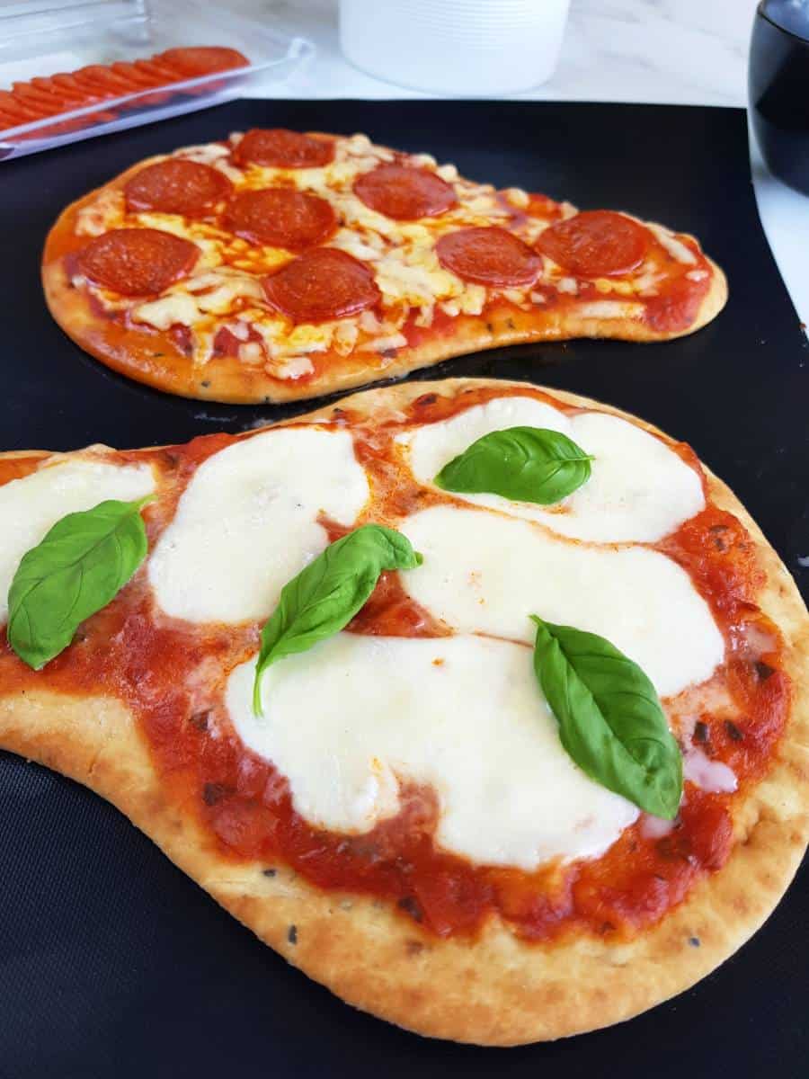 Margherita naan pizza on a baking sheet.