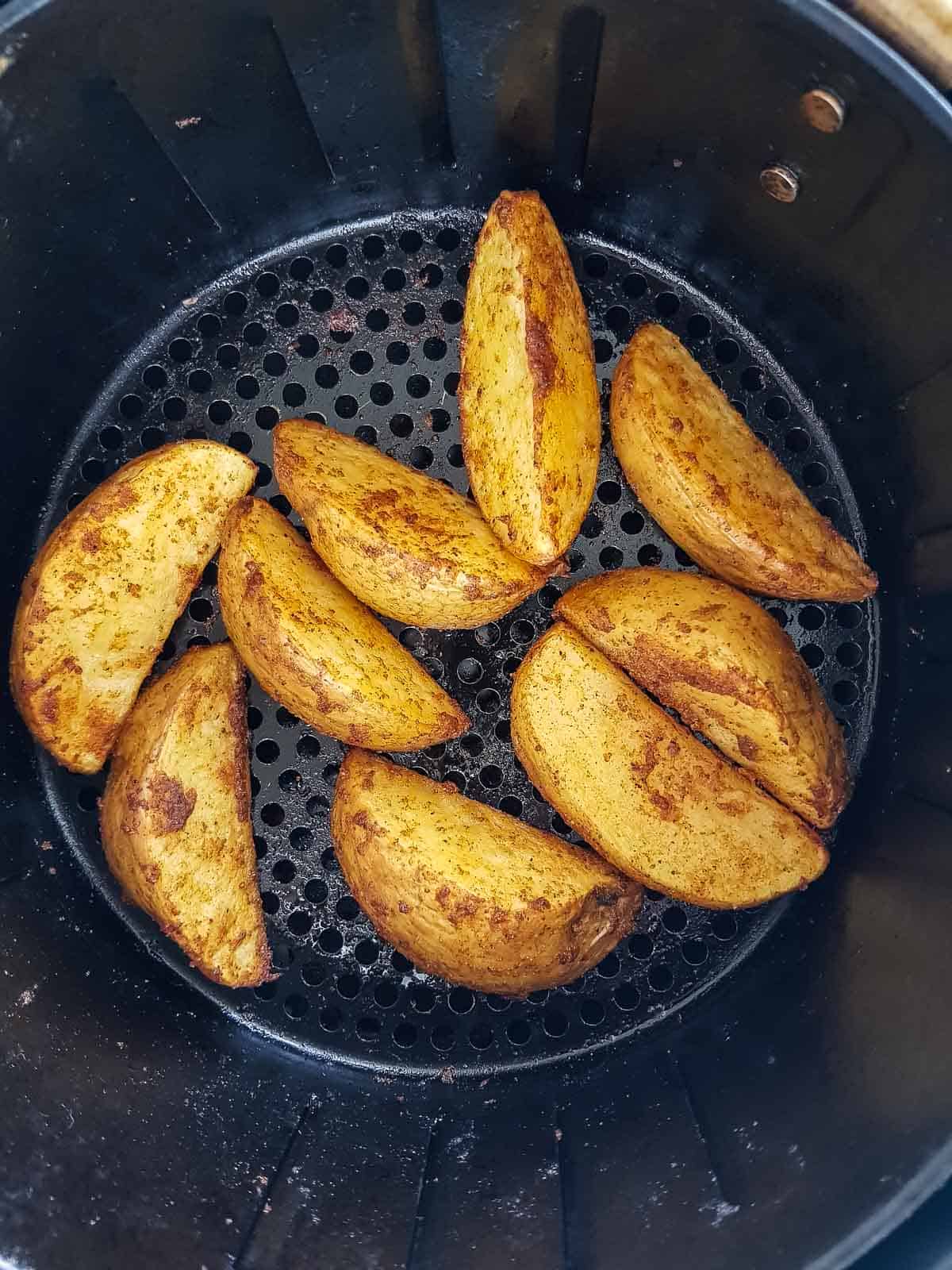 Potato wedges in an air fryer.