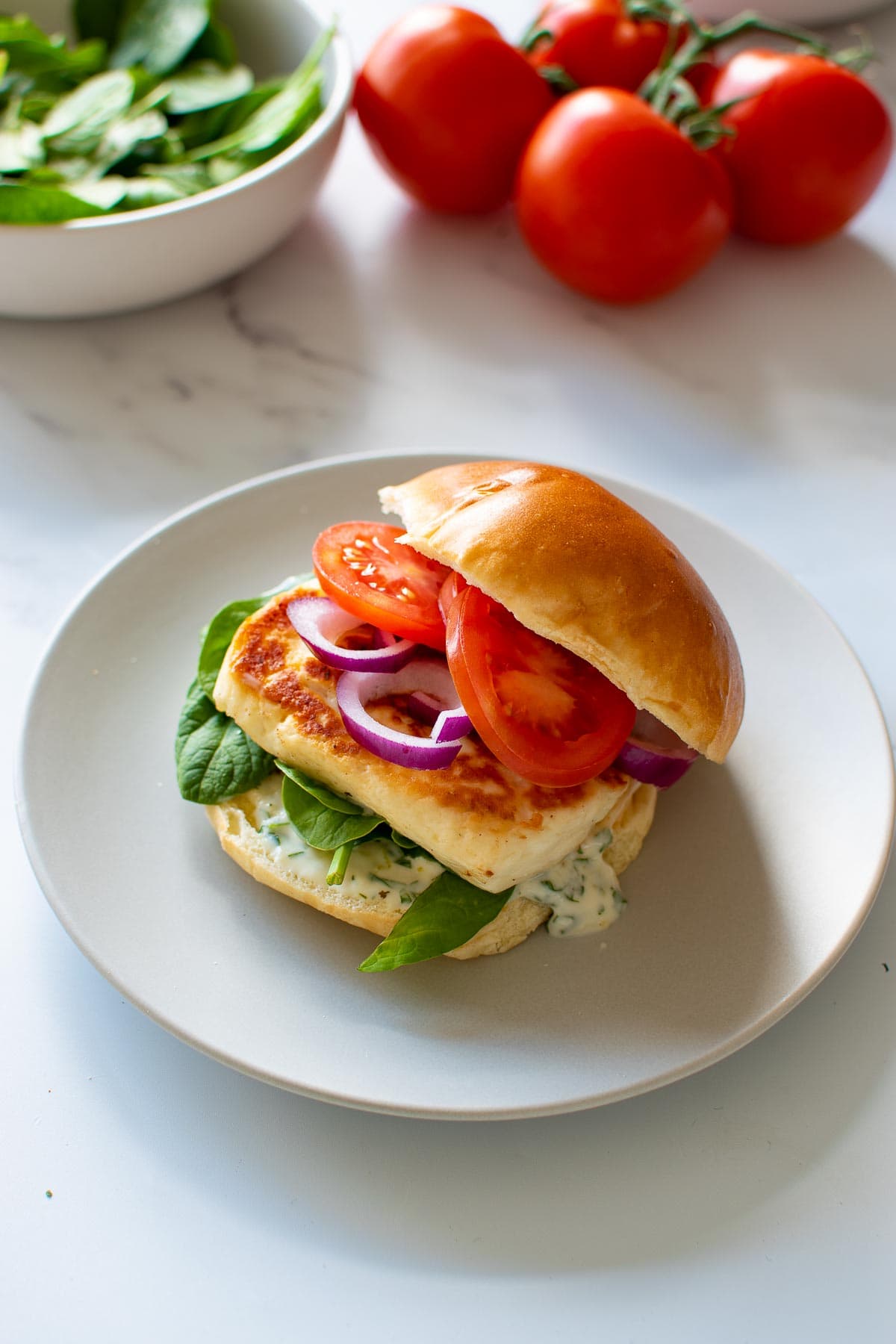 Halloumi burger with salad in the background.
