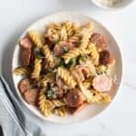Pasta with kielbasa sausage on a plate.